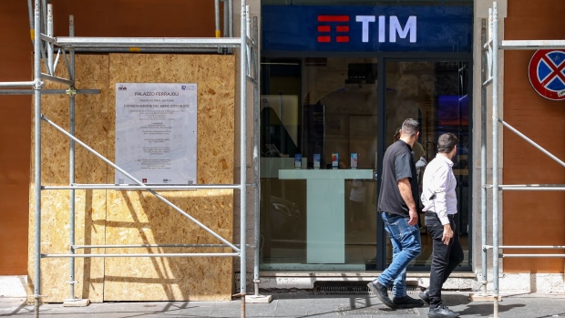 Pedestrians pass a Telecom Italia SpA store in Rome, Italy, on Tuesday, May 31, 2022. Telecom Italia is seeking an enterprise value of around 20 billion euros ($21.5 billion) for the landline network it plans to sell to Italy’s state lender and a group of international funds, according to people with knowledge of the matter.