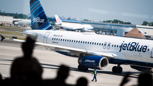 A JetBlue plane taxis outside of Terminal 5 at John F. Kennedy International Airport in New York. Photographer: Mark Kauzlarich/Bloomberg