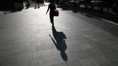 A silhouetted pedestrian near the Roppongi Hills complex in Tokyo, Japan, on Saturday, Oct. 1, 2022. Tankan business confidence and Tokyo CPI data at the start of the week will show the strength of price gains in September and the impact of inflation and global recession concerns on corporate activity. Photographer: Akio Kon/Bloomberg