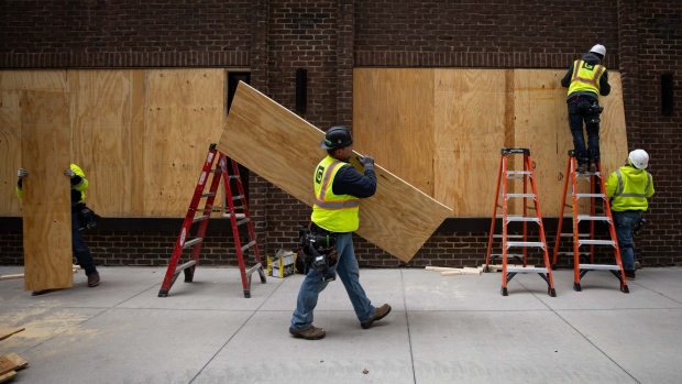 Construction workers board up business near the Hennepin County Government Center in Minneapolis, Minnesota, U.S.
