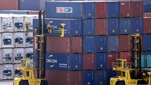 A container handler, left, moves a container at a shipping terminal in Yokohama, Japan, on Monday, July 18, 2022. Japan is scheduled to release trade balance figures on July 21. Photographer: Kiyoshi Ota/Bloomberg