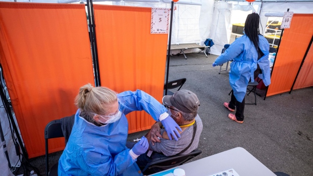 A healthcare worker administers a Pfizer-BioNTech Covid-19 vaccine at a vaccination site in San Francisco, California, U.S., on Monday, Jan. 10, 2022. California Governor Gavin Newsom is proposing a $2.7 billion Covid-19 emergency response package in his budget Monday to boost testing and its health-care system following a surge in cases caused by the omicron variant. Photographer: David Paul Morris/Bloomberg