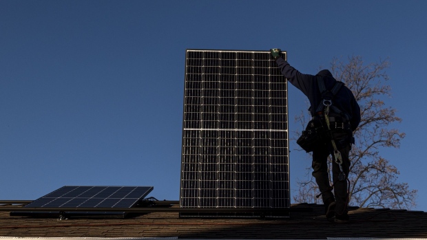 A contractor carries a SunRun solar panel on the roof of a home in San Jose, California, U.S., on Monday, Feb. 7, 2022. California regulators are delaying a vote on a controversial proposal to slash incentives for home solar systems as they consider revamping the measure.