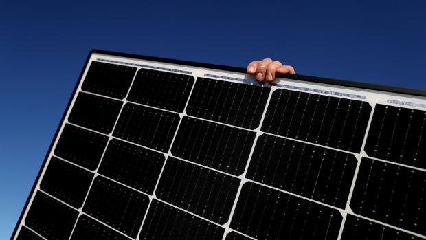 A Solarpro employee holds a LG Electronics Inc. NeON R 370W solar panel ahead of installation on the rooftop of a residential property in Sydney, Australia, on Monday, May 17, 2021. Australia is the global leader in generating electricity from the sun. Some 27% of buildings had a solar system on their roof at the end of 2020, the highest proportion in the world, according to figures from BNEF. Photographer: Brendon Thorne/Bloomberg
