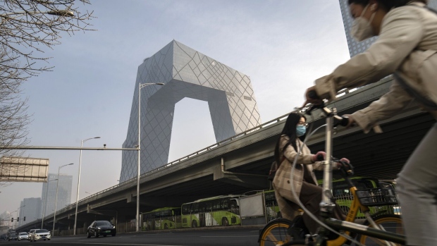 Cyclists travel past the CCTV headquarters building in Beijing, China, on Monday, March 6, 2023. China set a modest economic growth target of around 5% for the year, with the nation’s top leaders avoiding any large stimulus to spur a consumer-driven recovery already underway, suggesting less of a growth boost to an ailing world economy. Photographer: Qilai Shen/Bloomberg