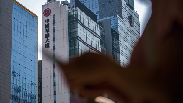 A pedestrian walks past the China Huarong Tower, which houses the headquarters of China Huarong International Holdings Ltd., a unit of China Huarong Asset Management Co., center, in Hong Kong, China, on Tuesday, April 13, 2021. Growing panic over the financial health of one of China’s largest bad-debt managers China Huarong Asset Management Co. spilled into the broader market, as traders circulated a Caixin report that openly considered the worst-case scenario for the company. Photographer: Lam Yik/Bloomberg