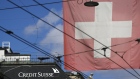 A Swiss national flag flies alongside the Credit Suisse Group AG headquarters in Zurich, Switzerland, on Thursday, April 8, 2021. Credit Suisse Chief Executive Officer Thomas Gottstein gathered dozens of managing directors at the global bank on a conference call late Tuesday, as part of crisis-management efforts after the lender announced that it stands to lose as much as $4.7 billion amid the meltdown of hedge fund Archegos Capital Management. Photographer: Stefan Wermuth/Bloomberg
