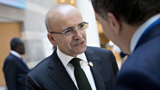 Mehmet Simsek, Turkey's deputy prime minister, talks to Nicolas Dujovne, Argentina's treasury minister, right, before a Group of 20 (G-20) finance ministers and central bank governors meeting on the sidelines of the spring meetings of the International Monetary Fund (IMF) and World Bank in Washington, D.C., U.S., on Friday, April 20, 2018. The IMF said this week the world's debt load has ballooned to a record $164 trillion, a trend that could make it harder for countries to respond to the next recession and pay off debts if financing conditions tighten.