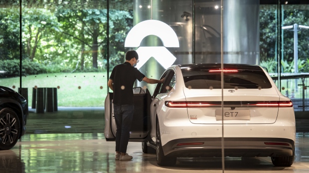 Employees stand next to a ET7 sedan at a NIO Inc. dealership in Shanghai, China, on Wednesday, June 8, 2022. Photographer: Qilai Shen/Bloomberg