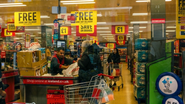 A customer at the checkout in an Iceland Foods Ltd. supermarket at Watney Market in the Tower Hamlets district of London on March 18. Photographer: Jose Sarmento Matos/Bloomberg