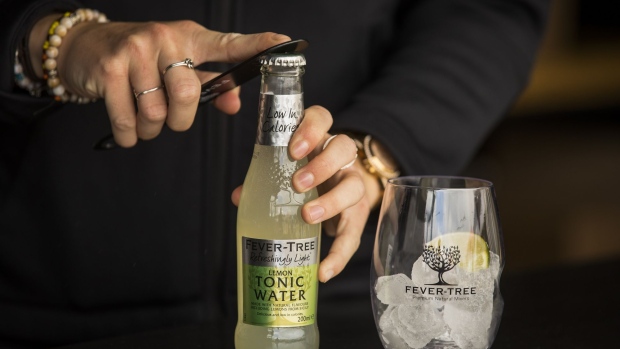 An employee opens a bottle of tonic water at the Fevertree Drinks Plc Gin and Tonic bar during the annual Cowes Week sailing regatta near Cowes on the Isle of Wight, U.K. on Tuesday, Aug. 13, 2019. A cool start to summer contributed to U.K. sales rising just 5% in the opening six months of the year, an outcome that disappointed most analysts, particularly in light of the stellar growth rates of recent years.