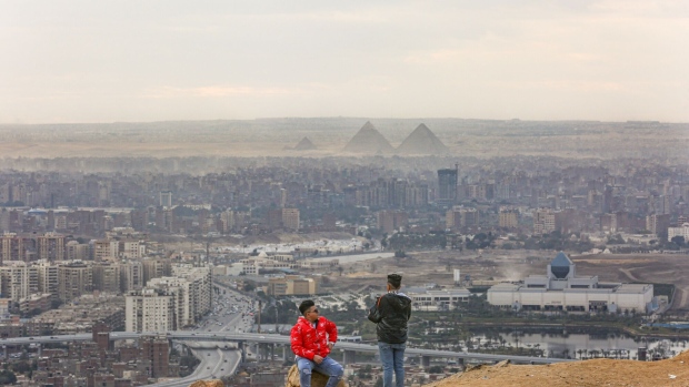 Visitors look out towards the Giza pyramid complex, viewed from Al Mokattam mountain, in Cairo, Egypt, on Saturday, Jan. 7, 2023. Egypt’s urban inflation accelerated at its fastest pace in five years as several rounds of currency devaluation filtered through to consumers.