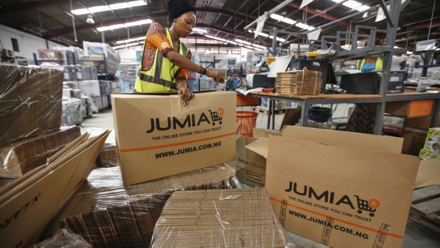 A worker packages goods inside branded cardboard boxes inside a Jumia Technologies AG distribution warehouse in Lagos, Nigeria, on Friday, April 12, 2019. Jumia shares soared by 75 percent on their first day of trading in New York, as investors rushed to buy into the company’s plans to extend online shopping services across Africa.