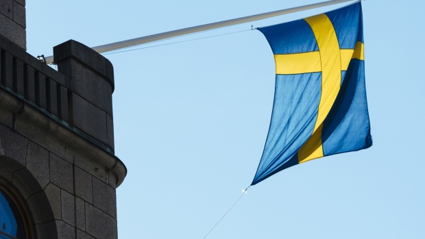 A national flag of Sweden hangs from a commercial building in Stockholm, Sweden. Photographer: Mikael Sjoberg/Bloomberg