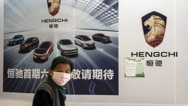 A pedestrian walks past China Evergrande Group New Vehicle Group Ltd.'s yet-to-open Hengchi showroom in Shanghai, China, on Friday, April 2, 2021. China Evergrande Group's new-energy vehicle startup Evergrande NEV reported a loss that widened by a yawning 67% with still no immediate sign of mass production of electric cars. Photographer: Qilai Shen/Bloomberg