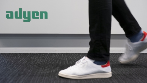 An employee passes a logo on a wall inside the Adyen NV headquarters in Amsterdam, Netherlands, on Monday, Oct. 29, 2018. Investors have flocked to fintech company Adyen, whose shares have risen from 240 euros at the time of the IPO, to as much as 609 euros a month later. Photographer: Jasper Juinen/Bloomberg
