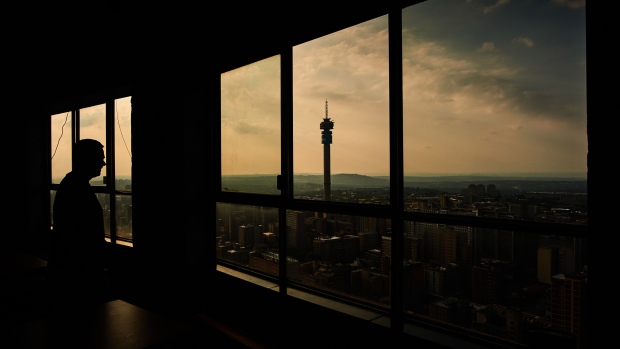 A visitor looks out towards the Telkom Tower and city skyline from the Ponte City Apartments building in the Berea district of Johannesburg, South Africa, on Thursday, Dec. 22, 2022. Johannesburg, South Africa’s economic hub and its richest city, is seeking electricity supply from private generators to reduce the amount of scheduled power outages. Photographer: Waldo Swiegers/Bloomberg