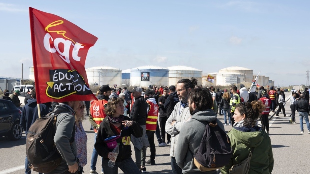 Striking members of the General Confederation of Labour (CGT) and other unions block the road to oil refineries in the industrial and port area of Fos-sur-Mer, France, on Wednesday, March 22, 2023. France released strategic stockpiles of oil products this month as the latest round of strike action over pension reforms hobbles the nation's fuel distribution network.