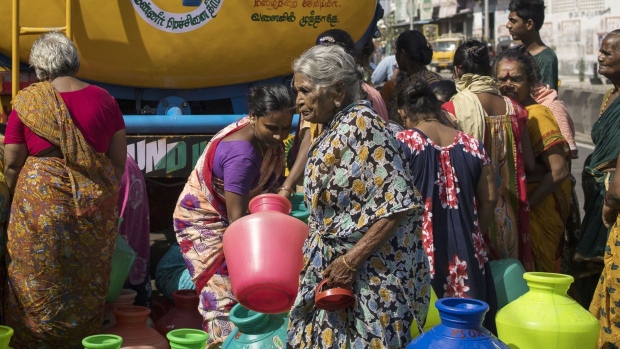 Residents wait in line to fill pots from a water truck in Chennai, India, on Wednesday, Sept. 22, 2021. Indian finance ministry officials plan to pitch for a sovereign rating upgrade from Moody’s Investors Service when it meets with the firm, scheduled for Sept. 28, according to people familiar with the matter.