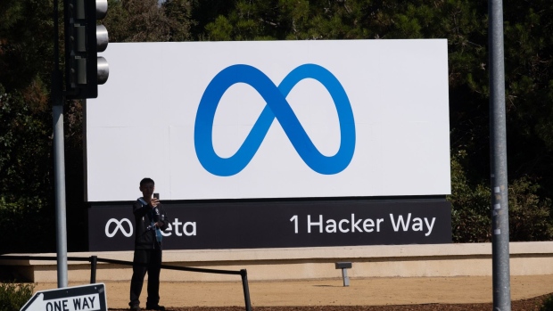 A visitor takes photographs in front of signage at Meta Platforms headquarters in Menlo Park, California, U.S., on Friday, Oct. 29, 2021. Facebook Inc. is re-christening itself Meta Platforms Inc., decoupling its corporate identity from the eponymous social network mired in toxic content, and highlighting a shift to an emerging computing platform focused on virtual reality. Photographer: Nick Otto/Bloomberg