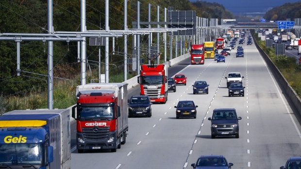 A Scania AB R450 cargo truck, center left, powered by overhead electrical power lines, drives alongside other traffic on the A5 autobahn between Frankfurt and Darmstadt, Germany, on Thursday, Oct. 17, 2019. Volkswagen AG's Traton truck division plans to spend more than 2 billion euros ($2.2 billion) over the next five years on electric vehicles and digital offerings in a bid to keep pace with the industry's radical transformation.