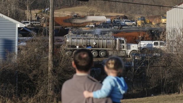 A family inspects the wreckage of the Norfolk Southern train derailment in East Palestine, Ohio, US, on Feb. 19.