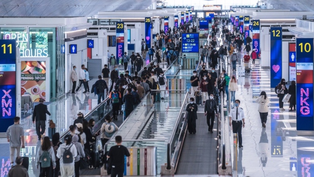 Travelers at Hong Kong International Airport in Hong Kong, China, on Friday, Feb. 17, 2023. A scarcity of workers in the air industry is hobbling Hong Kong's efforts to reestablish the international links vital for its role as a financial hub.