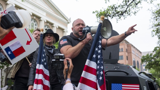 Alex Jones, radio host and creator of the website InfoWars, center, speaks into a megaphone as demonstrators gather during a 'You Can't Close America' rally outside the Texas State Capitol in Austin, Texas, U.S., on Saturday, April 18, 2020. Protesters gathered at the State Capitol Saturday to call for the reopening of the state amid the coronavirus pandemic. Photographer: Alex Scott/Bloomberg