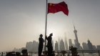 China Customs officers raise a Chinese flag during a rehearsal for a flag-raising ceremony along the Bund past buildings in the Lujiazui Financial District at sunrise in Shanghai, China, on Tuesday, Jan. 4, 2022. A wall of maturing debt and a surge in seasonal demand for cash will test China’s financial markets this month, putting pressure on the central bank to ensure sufficient liquidity. Photographer: Qilai Shen/Bloomberg