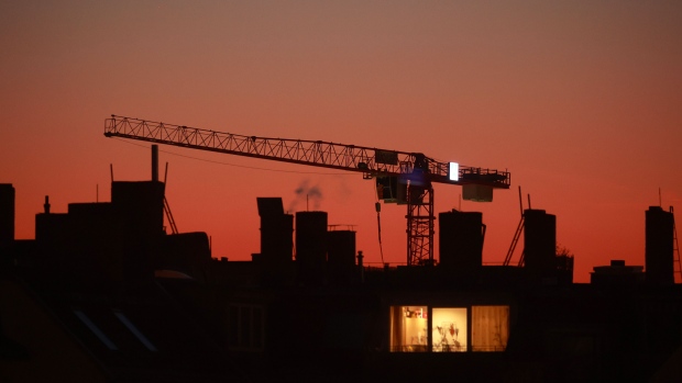 A construction crane beyond an apartment building at dusk in the Prenzlauer Berg district in Berlin, Germany, on Thursday, Feb. 9, 2023. Berlin’s new tech recruits are being told to take any apartment they can get as the city's housing crunch means startups in Berlin have lost an important edge, putting them on similar footing to rivals in London, Paris and Silicon Valley. Photographer: Krisztian Bocsi/Bloomberg