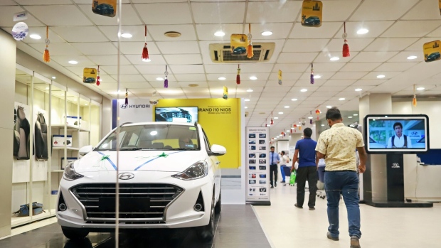 Customers walk past a Hyundai Motor Co. vehicle at the company's Koncept Hyundai showroom in New Delhi, India, on Tuesday, Sept. 24, 2019. Hyundai launched India's first electric SUV this summer with a quirky TV commercial urging millennials to "Drive Into the Future." Photographer: Anindito Mukherjee/Bloomberg