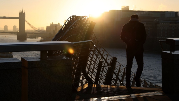 A morning commuter heads towards the Thames Path from London Bridge in the City of London.