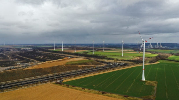 Wind turbines, operated by RWE AG, operate beside the Garzweiler open cast lignite mine in this aerial photograph taken in Grevenbroich, Germany, on Monday, March 15, 2021. Axa SA, France's biggest insurer, is dropping German energy giant RWE as a client in a decision that highlights how taboo the coal business has become. Photographer: Alex Kraus/Bloomberg