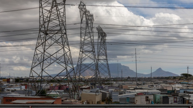 Electricity transmission pylons in the Dunoon informal settlement in Cape Town, South Africa, on Thursday, March 3, 2022. Eskom Holdings SOC Ltd., South Africa’s indebted power utility, is considering selling distribution assets as prospects of the government taking over about half of its 392 billion rand ($26 billion) obligations dim, people with knowledge of the matter said. Photographer: Dwayne Senior/Bloomberg