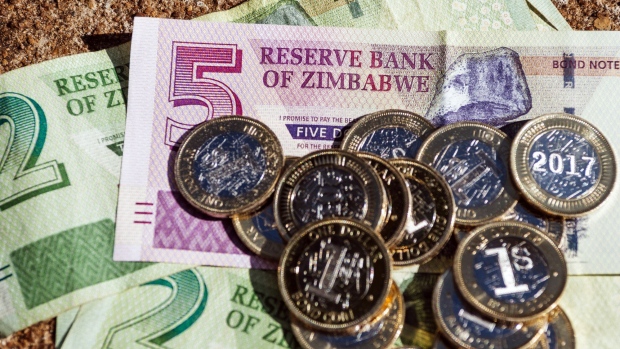 Zimbabwean one dollar bond coins, nicknamed “zollars”, sit on top of five and two dollar bond banknotes in an arranged photo in Harare, Zimbabwe, on Friday, Dec. 29, 2017. Zimbabwean President Emmerson Mnangagwa said his new administration will woo investors and embark on an “all-out business initiative” to revive an economy that has halved since 2000 and provides jobs for just one in 10 Zimbabweans.