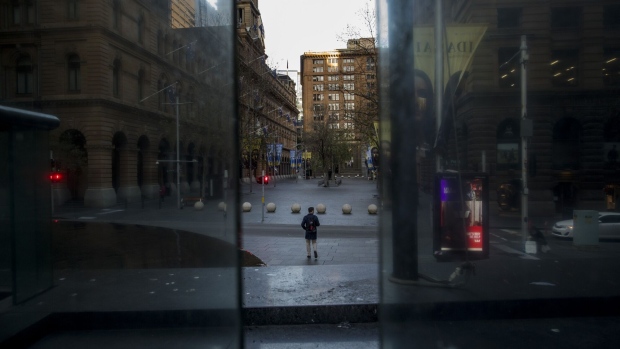 A pedestrian walks through a deserted Martin Place in Sydney, Australia, on Monday, Aug. 2, 2021. Sydney’s lockdown has been extended three times times and there is a risk it won’t be lifted as currently scheduled on Aug. 28, given delta’s continued spread and Australia’s vaccination program that has lagged many other major economies. Photographer: Brent Lewin/Bloomberg