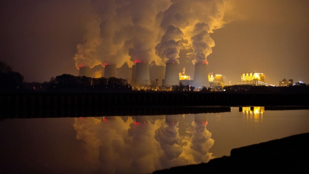 Chimneys emit vapor at Jaenschwalde lignite power plant, operated Vattenfall AB, at dusk in Peitz, Germany. Photographer: Krisztian Bocsi/Bloomberg