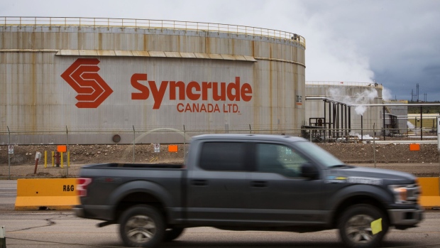 A truck drives past the Syncrude Canada Ltd. facility in the Athabasca oil sands near Fort McMurray, Alberta, Canada, on Sunday, Sept. 9, 2018. New technologies such as driverless trucks and froth-treatments that eliminate the need for multibillion-dollar upgraders -- along with U.S. benchmark crude prices closer to $70 -- are helping make the industry profitable again.