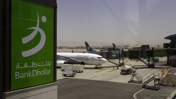 An advertisement for Bank Dhofar SAOG sits on display in the passenger terminal at Muscat International Airport in Muscat, Oman, on Monday, May 7, 2018. Being the Switzerland of the Gulf served the country well over the decades, helping the sultanate survive, thrive and make it a key conduit for trade and diplomacy in the turbulent Middle East. Photographer: Christopher Pike/Bloomberg