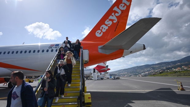 Passengers disembark an EasyJet Plc passenger airport at Madeira Airport, operated by ANA Aeroportos de Portugal SA, in Funchal, Portugal, on Sunday, Feb. 5, 2023. For Portugal, which has the third-highest debt ratio in the euro area behind Greece and Italy, tourism represents about 15% of the economy. Photographer: Zed Jameson/Bloomberg