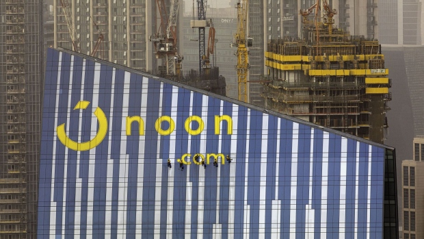 Workers wash the windows of a building displaying a Noon.com logo near skyscrapers under construction in Dubai, United Arab Emirates, on Tuesday, July 23, 2019. Like the rest of the city, the business center has suffered from a prolonged real-estate slump brought on by oversupply and slower economic growth. Photographer: Christopher Pike/Bloomberg