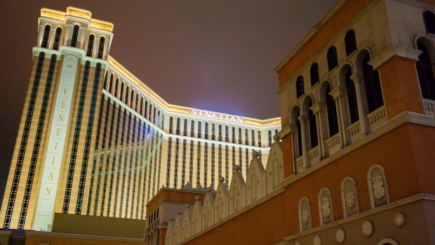 The Venetian Macao resort and casino, operated by Sands China Ltd., a unit of Las Vegas Sands Corp., left, stands illuminated at night in Macau, China, on Tuesday, March 3, 2020. Casinos in Macau, the Chinese territory that's the world’s biggest gambling hub, reported a record drop in gaming revenue, as they grappled with the cost of closing down their businesses for 15 days to help contain the deadly coronavirus outbreak. Photographer: Billy H.C. Kwok/Bloomberg