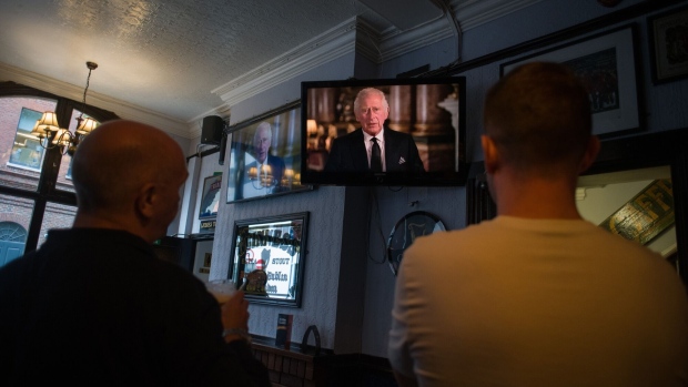 Customers watch the first broadcast by King Charles III to the nation and commonwealth on the first day of public mourning, following the death of Queen Elizabeth II, at the King and Queen pub in London, UK, on Friday, Sept. 9, 2022. Elizabeth II’s death at the age of 96 marks the start of a tumultuous 10 days for the UK that will see a queen buried, a nation mourn its longest-reigning monarch, and a new king proclaimed. Photographer: Nathan Laine/Bloomberg
