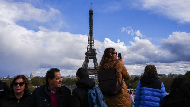 Tourists take photographs of the Eiffel tower at Trocadero Square in Paris, France, on Wednesday, April 12, 2023. In recent months, big banks like Goldman Sachs, Bank of America, Deutsche Bank and Citigroup expanded their presence in the French capital, ushering in a new reality for the landscape of European banking.