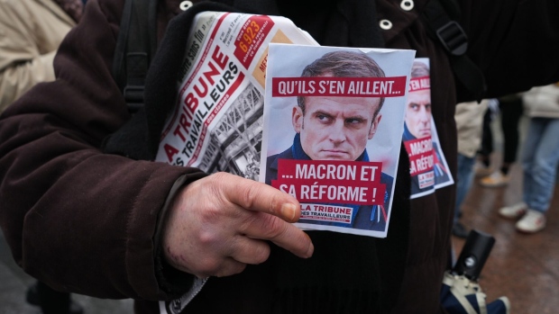 A protestor holds a poster featuring French President Emmanuel Macron during a demonstration following the pension reform ruling in central Paris, France, on Friday, April 14, 2023. France's Constitutional Council cleared Emmanuel Macrons plan to raise the retirement age, giving the French President a boost in his attempt to turn the page on an episode that has left him deeply unpopular and compromised his ability to enact further legislation.