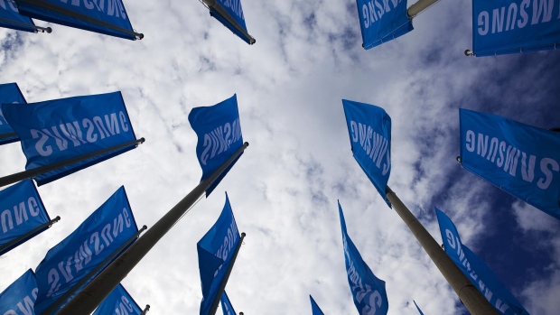 The Samsung Electronics Co. Ltd logo sits on banners flying outside the venue ahead of the opening of the IFA consumer electronics show in Berlin, Germany, on Wednesday, Sept. 4, 2013.  Photographer: Krisztian Bocsi/Bloomberg