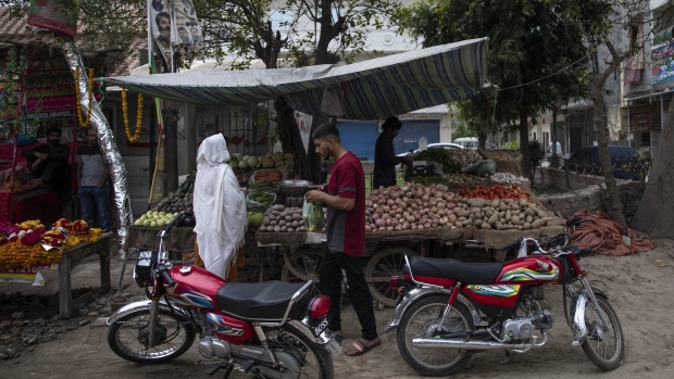 A person purchases vegetables from a stall in a residential area in Lahore, Pakistan, on March 30, 2023. Rising inflation and tax hikes implemented to fulfill aid terms from the International Monetary Fund are eroding consumer purchasing power, according to Bloomberg Economics.