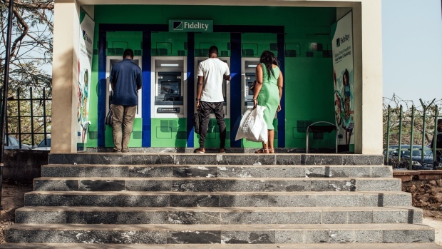 Customers use Fidelity Bank Plc branded automatic teller machines (ATM) in Abuja, Nigeria, on Friday, Jan. 10, 2020. Revenue in Nigeria has fallen short of the government target by at least 45% every year since 2015, and shortfalls have been funded through increased borrowing. Photographer: KC Nwakalor/Bloomberg