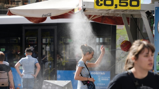 A customer stands under a cooling mist spray at a street kiosk during high temperatures in central Madrid, Spain, on Thursday, April 27, 2023. Spring in Spain will resemble the middle of the summer this week as thermometers rise above 30 degrees Celsius (86 Fahrenheit) and some regions are forecast to hit 40 Celsius (104 Fahrenheit).