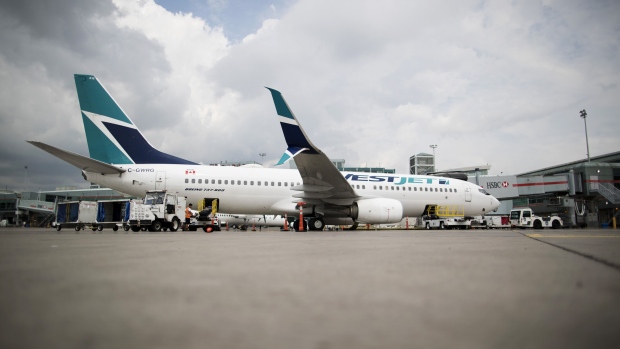 A Boeing Co. 737-800 WestJet Airlines plane sits at a gate at Toronto Pearson International Airport (YYZ) in Toronto, Ontario, Canada, on Monday, July 22, 2019. In 2018, 49.5 million passengers traveled through Pearson on 473,000 flights.